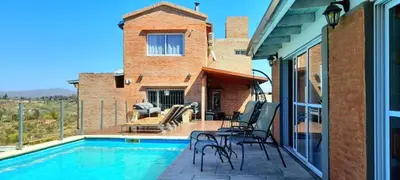 a patio with a pool and chairs and a house at Casa Serrana Mirador del Lago - Casa con Quincho in Bialet Massé