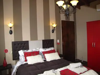 a bedroom with a large bed with red and white pillows at Casa Serrana Mirador del Lago - Casa con Quincho in Bialet Massé