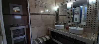 a bathroom with two sinks and two mirrors at Casa Serrana Mirador del Lago - Casa con Quincho in Bialet Massé