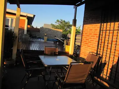 a patio with a table and chairs on a balcony at Casa Serrana Mirador del Lago - Casa con Quincho in Bialet Massé