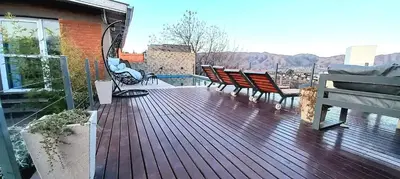 a deck with chairs and a pool on a house at Casa Serrana Mirador del Lago - Casa con Quincho in Bialet Massé