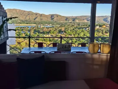 a table with a view of the mountains from a window at Casa Serrana Mirador del Lago - Casa con Quincho in Bialet Massé