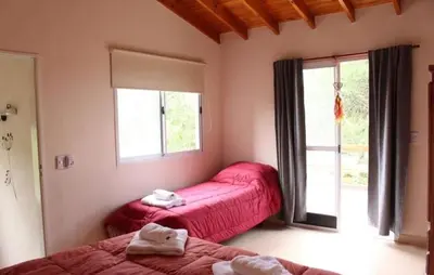 a bedroom with two beds and a window at Cabañas Amaneciendo in Merlo