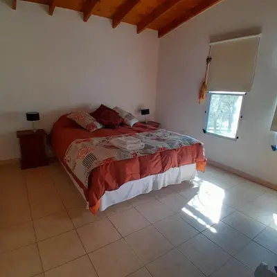 a bedroom with a large bed in a room at Cabañas Amaneciendo in Merlo