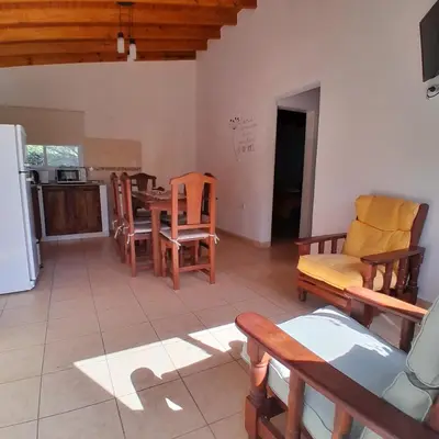 a kitchen and living room with a table and chairs at Cabañas Amaneciendo in Merlo