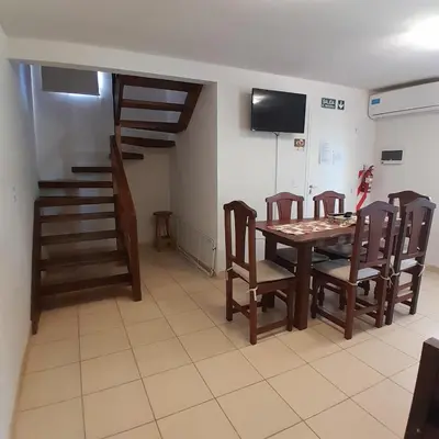 a dining room with a table and chairs and a television at Cabañas Amaneciendo in Merlo
