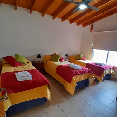 a bedroom with three beds in a room at Cabañas Amaneciendo in Merlo