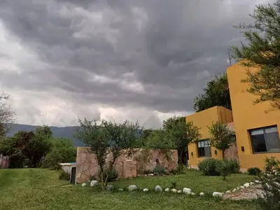 a house in a yard next to a building at Casa Magnolia in Merlo