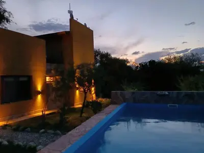 a villa with a swimming pool in front of a house at Casa Magnolia in Merlo
