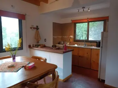a kitchen with a wooden table and a wooden table and a table and a kitchen at Casa Magnolia in Merlo