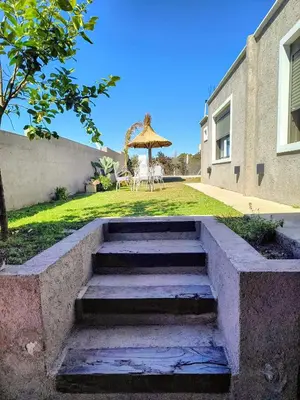 a set of stairs leading to a yard with an umbrella at Casa a 5 minutos de Villa Carlos Paz in Villa San Nicolás
