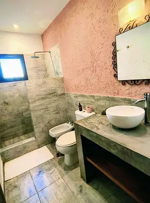 a bathroom with a sink and a toilet and a mirror at Casa a 5 minutos de Villa Carlos Paz in Villa San Nicolás