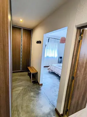 a room with a bed and a door leading to a bedroom at Casa a 5 minutos de Villa Carlos Paz in Villa San Nicolás
