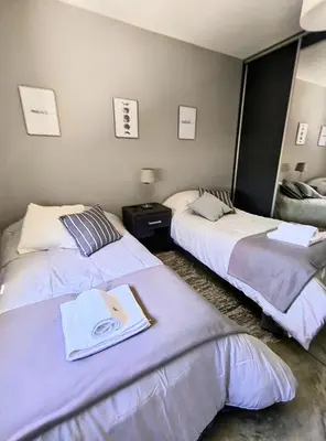 two beds in a hotel room with a book at Casa a 5 minutos de Villa Carlos Paz in Villa San Nicolás