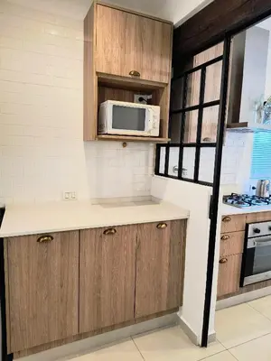 a kitchen with wooden cabinets and a microwave at Casa a 5 minutos de Villa Carlos Paz in Villa San Nicolás