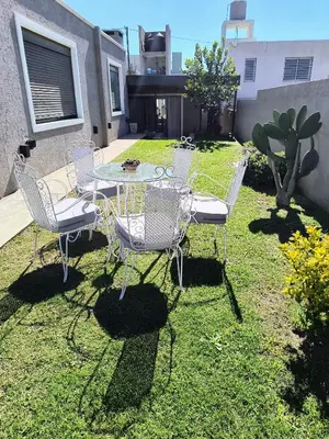 a table and chairs sitting in the grass at Casa a 5 minutos de Villa Carlos Paz in Villa San Nicolás