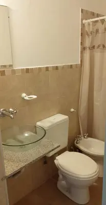 a bathroom with a toilet and a glass sink at Departamento del golf in Alta Gracia