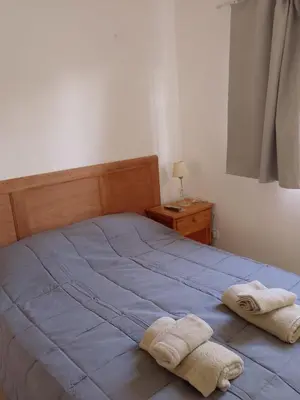 a bedroom with a bed with two towels on it at Departamento del golf in Alta Gracia