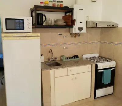 a small kitchen with a sink and a stove at Departamento del golf in Alta Gracia