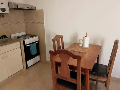 a kitchen with a wooden table and a stove at Departamento del golf in Alta Gracia