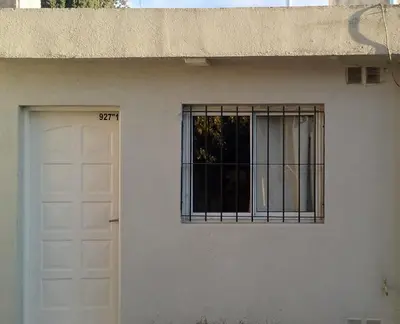 a white house with a door and a window at Departamento del golf in Alta Gracia