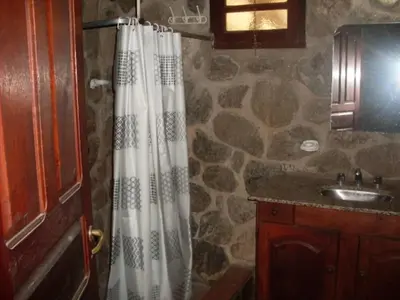 a bathroom with a shower curtain and a sink at Cabañas Mc Charlie in Santa Rosa de Calamuchita