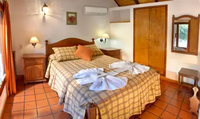 a bedroom with a bed with towels on it at Graz Hauser Cabañas in Villa General Belgrano