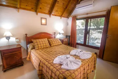 a bedroom with a bed with towels on it at Graz Hauser Cabañas in Villa General Belgrano