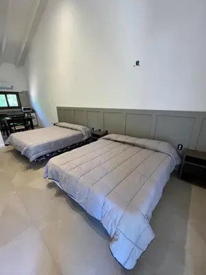 two beds sitting in a room with at Graz Hauser Cabañas in Villa General Belgrano