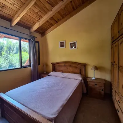 a bedroom with a large bed and a window at Aparts Duendes del Arroyo in Villa General Belgrano