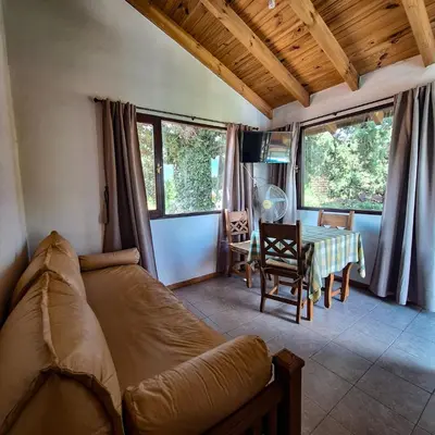a living room with a couch and a table at Aparts Duendes del Arroyo in Villa General Belgrano