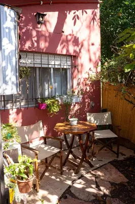 a wooden table and two chairs next to a building at Casita Meraki para 2 personas in Villa Carlos Paz