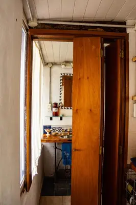 a small kitchen with a wooden door and a table at Casita Meraki para 2 personas in Villa Carlos Paz