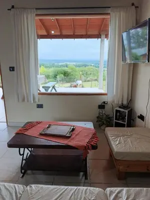 a room with a table in front of a window at Casa moderna y nueva, vista a las sierras con cercanía al rio in Los Reartes