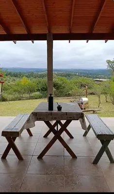 a picnic table and two benches on a patio at Casa moderna y nueva, vista a las sierras con cercanía al rio in Los Reartes