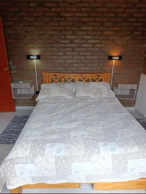 a bedroom with a large bed with two lamps at Casa moderna y nueva, vista a las sierras con cercanía al rio in Los Reartes