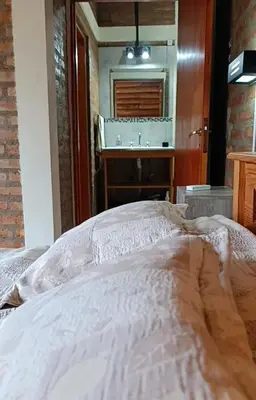 a bedroom with a bed and a vanity and a mirror at Casa moderna y nueva, vista a las sierras con cercanía al rio in Los Reartes