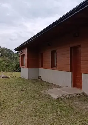 a wooden house with a door on the side of it at Casa moderna y nueva, vista a las sierras con cercanía al rio in Los Reartes