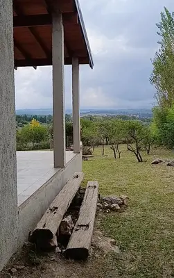 a wooden bench sitting on the side of a porch at Casa moderna y nueva, vista a las sierras con cercanía al rio in Los Reartes
