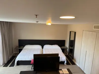 a bedroom with two beds and a tv in it at Graciana Residence H 11 JUNIO reserva mínima 3 noches in Trapiche