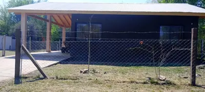 a fence in front of a blue building at Cabaña cp in Villa General Belgrano