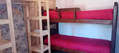 a room with two bunk beds with red sheets at Cabaña cp in Villa General Belgrano