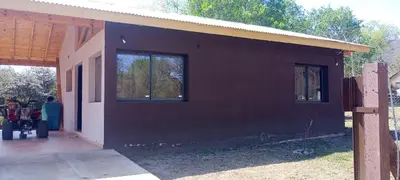 a house with a black wall and two windows at Cabaña cp in Villa General Belgrano