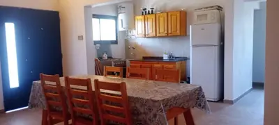 a kitchen with a table and a white refrigerator at Cabaña cp in Villa General Belgrano