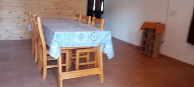 a wooden table and chairs with a table at Cabaña cp in Villa General Belgrano