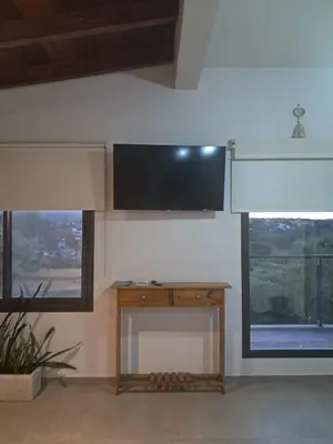 a room with a tv on a wall with windows at Terrazas al Golf in Alta Gracia