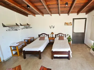 two beds in a room with wooden ceilings at Terrazas al Golf in Alta Gracia
