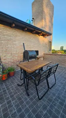 a picnic table and a grill on a patio at Terrazas al Golf in Alta Gracia