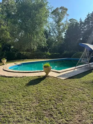 a swimming pool in a yard with a umbrella at Cabañas Altos Del Parque in Villa Ciudad Parque
