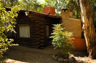 a log cabin with a small tree in front of it at Cabañas Altos Del Parque in Villa Ciudad Parque